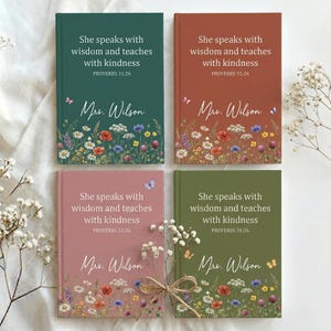 May include: Four hardcover journals in shades of green, rust, pink, and olive green. Each journal features the text "She speaks with wisdom and teaches with kindness" and "Mrs. Wilson" with floral and butterfly illustrations.