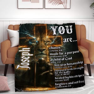 May include: A black blanket featuring a lion's face, a cross, and the name "Joseph" in white script. The blanket has text that reads "YOU are... chosen, made for a purpose, a child of God, his workmanship, healed by his stripes, forgiven and set free."
