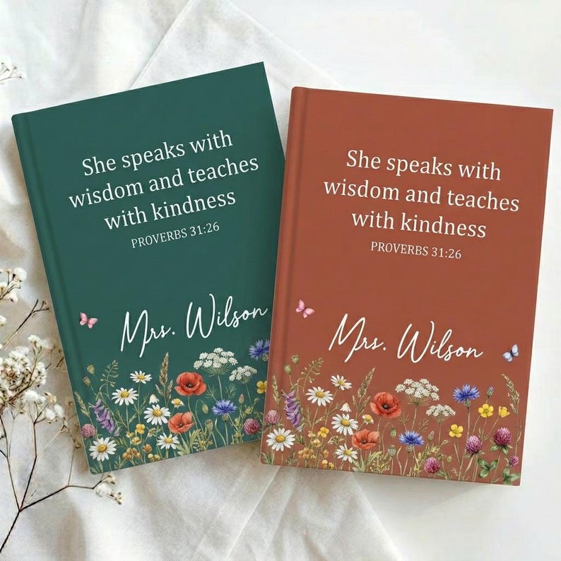 May include: Two hardcover journals, one teal and one rust-colored, with floral designs at the bottom. Each journal features the text "She speaks with wisdom and teaches with kindness PROVERBS 31:26" and the name "Mrs. Wilson".