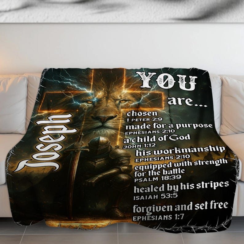 May include: A dark throw blanket with a lion's face and a cross design, with the name "Joseph" and the words "YOU are..." in white. The blanket also features Bible verses. The overall theme is religious and spiritual.