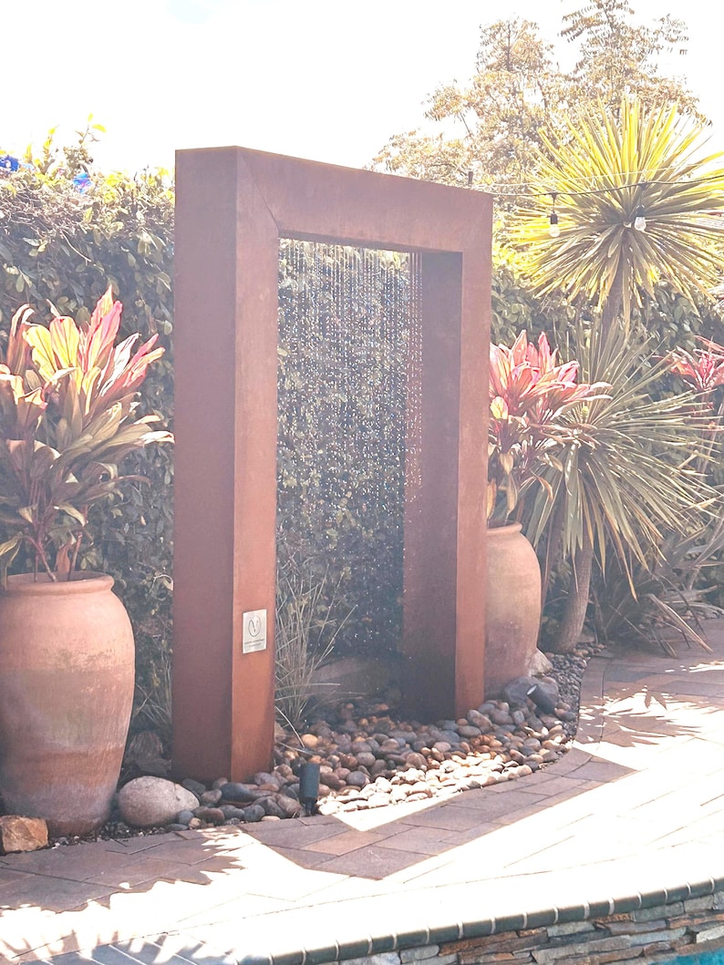 “Door style rain curtain fountain in corten steel — modern outdoor water feature, backyard garden decor, patio fountain for relaxation” “Corten steel rain curtain water feature — peaceful outdoor fountain for backyard, patio, or garden — creates calming waterfall sound” “Luxury corten steel rain curtain fountain — modern door design outdoor water feature for upscale backyard, pool, or garden oasis”