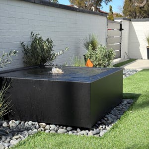 Fontaine de piscine extérieure moderne en acier noir enduit de poudre carrée de 48 po.. Lumière LED incluse, remplissage automatique et livraison aux États-Unis. Appelez le 858 842-7100.
