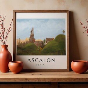 May include: A framed art print featuring a landscape with a castle, rolling green hills, and a blue sky. The print has the word "ASCALON" and "TYRIA" in black text at the bottom. The frame is brown.