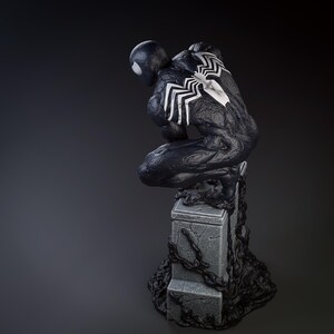 May include: Black and white figurine of a superhero in a crouching pose, standing on a stone base with black vines. The superhero has a black suit with white spider-like markings on the chest and back.