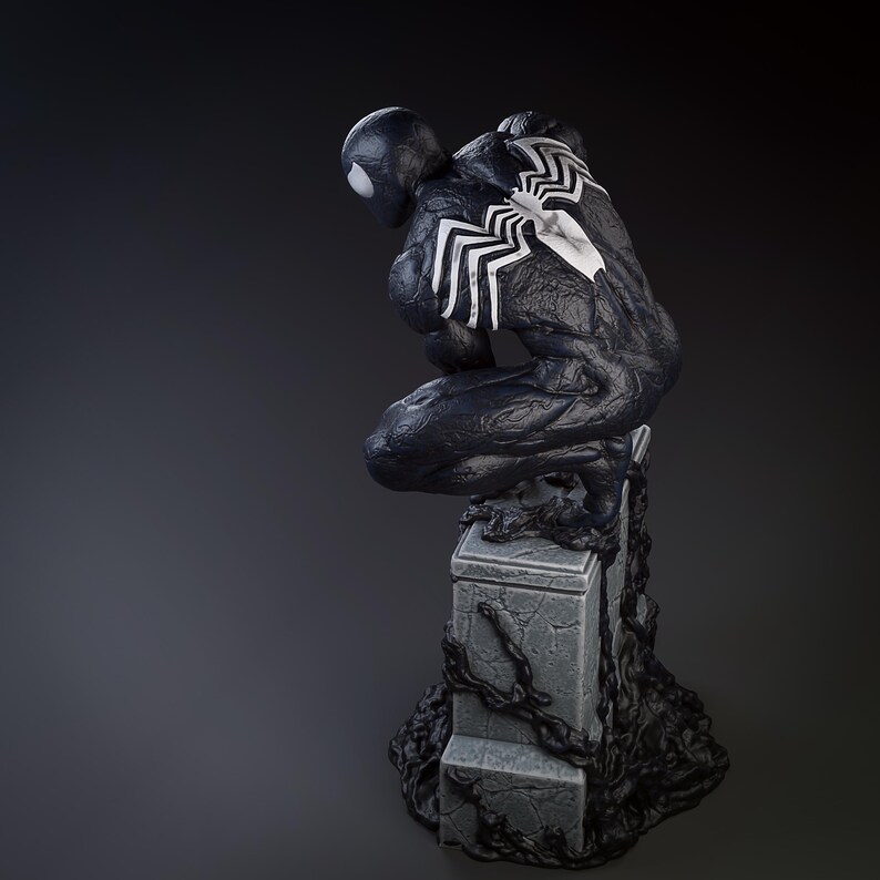 May include: Black and white figurine of a superhero in a crouching pose, standing on a stone base with black vines. The superhero has a black suit with white spider-like markings on the chest and back.