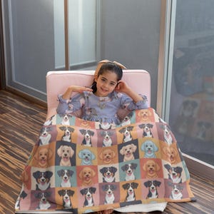 Puede incluir: Una colorida manta con temática de perros que presenta un patrón de cuadrícula de varias razas de perros. La manta muestra una variedad de retratos de perros en un patrón repetitivo, con una mezcla de colores que incluyen marrón, negro y beige. La manta está sobre una persona.