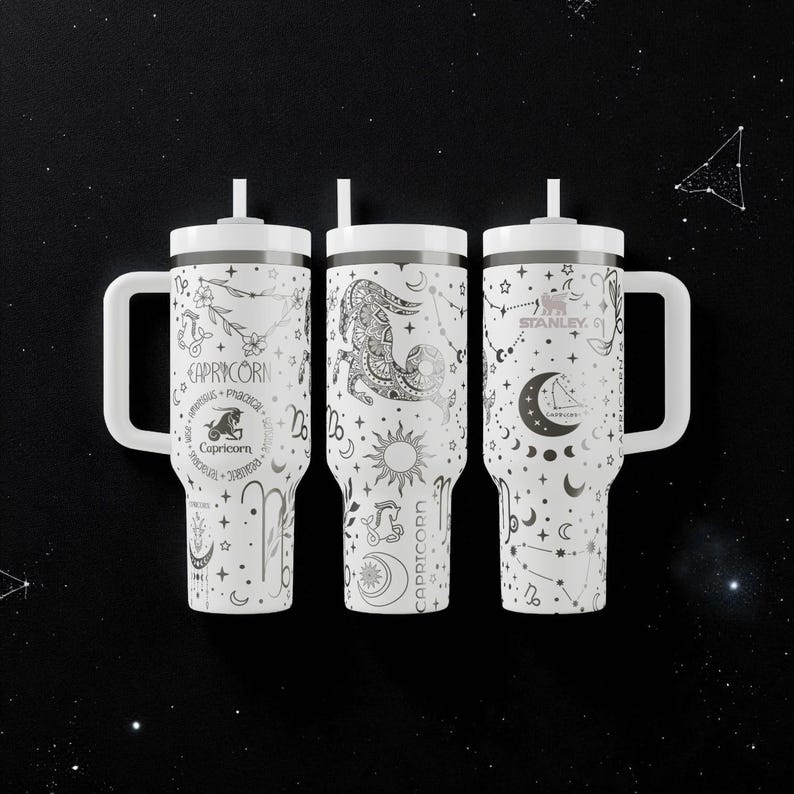 K&ouml;nnte beinhalten: Drei wei&szlig;e isolierte Becher mit Griffen und Strohhalmen, jeder mit einem anderen Capricorn-Tierkreiszeichen-Design in Schwarz. Die Becher haben einen wei&szlig;en Deckel und Griff. Der Text "Capricorn" ist auf jedem Becher sichtbar.