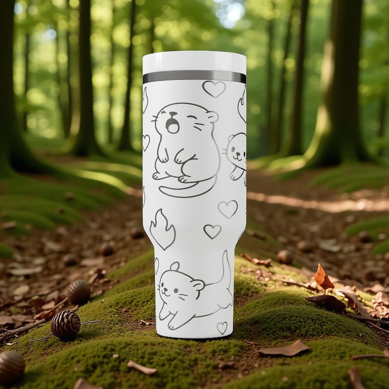 K&ouml;nnte beinhalten: Ein wei&szlig;er Becher mit einem sich wiederholenden Muster aus Cartoon-Ottern und Herzen. Der Becher hat einen wei&szlig;en Deckel und ein schwarzes Band in der N&auml;he der Oberseite. Das Design ist auf wei&szlig;em Hintergrund gedruckt. Geeignet f&uuml;r Hei&szlig;- und Kaltgetr&auml;nke.