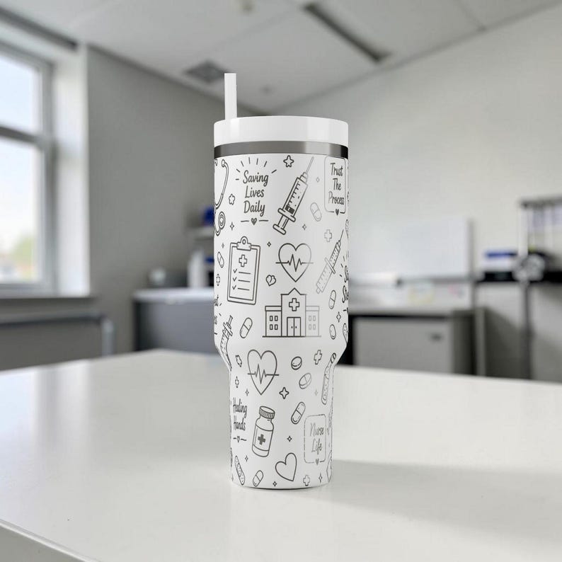 Puede incluir: Vaso blanco con un dise&ntilde;o m&eacute;dico en blanco y negro. El vaso presenta ilustraciones de herramientas m&eacute;dicas, un coraz&oacute;n y el texto "Saving Lives Daily" y "Trust The Process". Incluye tapa y pajita blancas.