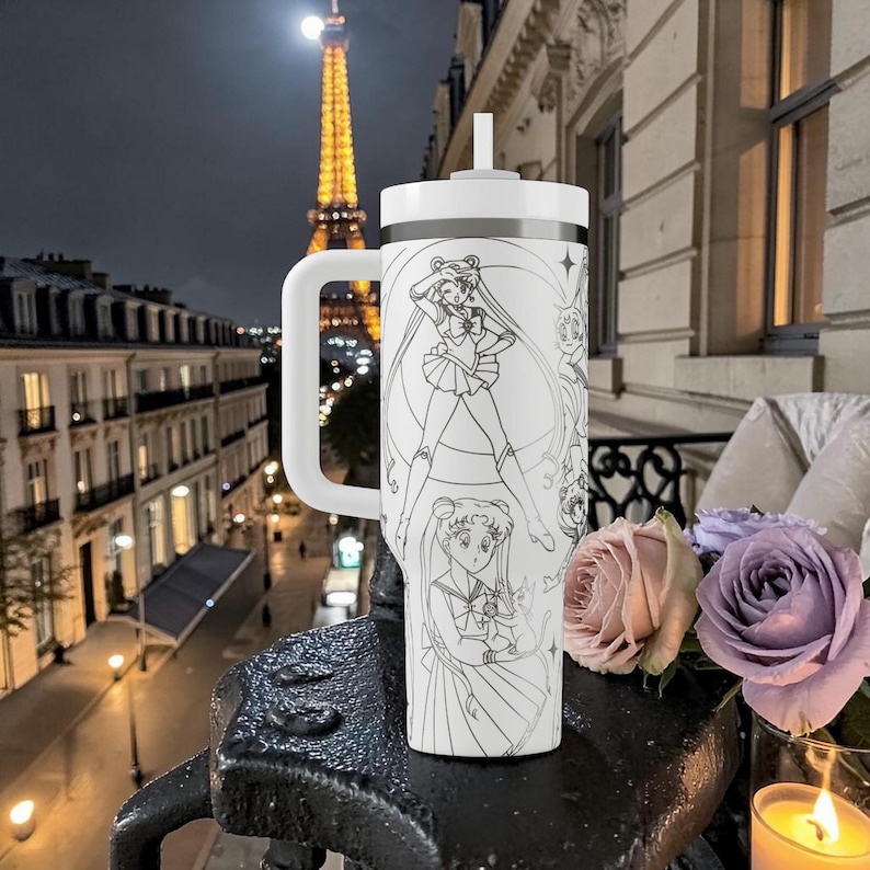 May include: A white tumbler with a handle and a straw, decorated with a black and white anime illustration. The background shows the Eiffel Tower at night, with a full moon and city lights.