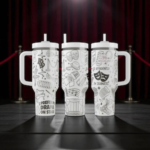 May include: Three white travel mugs with black line art of theater-related images and text. Each mug has a white handle, lid, and straw. The text on the mugs includes "I PREFER DRAMA ON STAGE" and "I'M DRAMATIC".