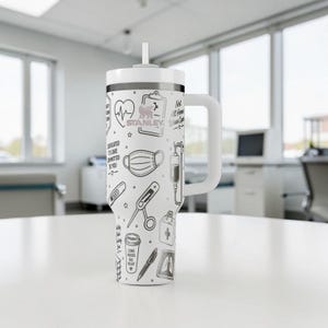 May include: White Stanley tumbler with a black and white medical-themed design. The design includes a heart rate monitor, medical mask, and IV drip. The tumbler has a white handle and a straw.