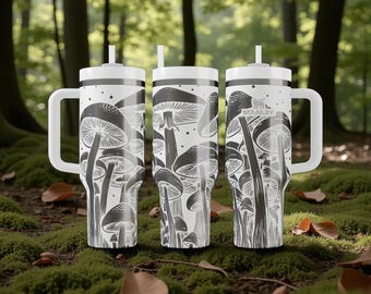 May include: Three white Stanley tumblers with handles and straws, featuring a black and white graphic print of various mushrooms. The tumblers have a cylindrical shape, a flat lid, and the Stanley logo is visible on the rightmost tumbler.