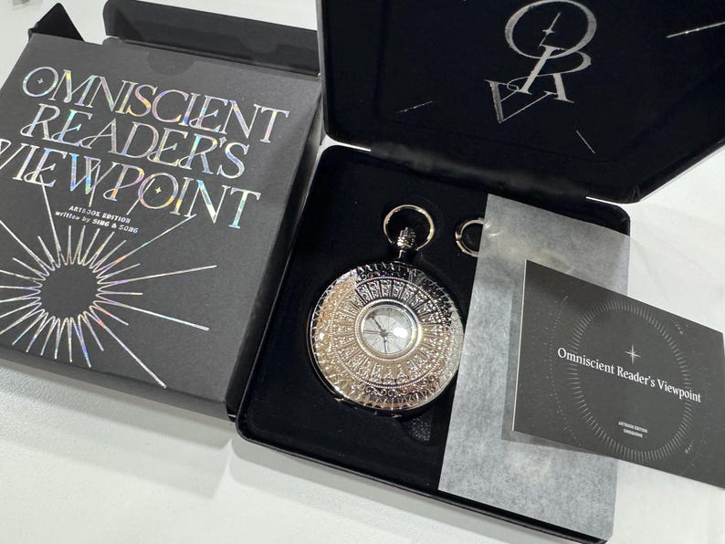 May include: A black box with the text "Omniscient Reader's Viewpoint" on the lid. The box contains a silver pocket watch with a detailed design and a black and white card with the same text as the box.