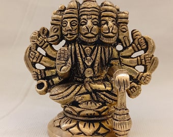 Könnte beinhalten: Eine goldfarbene Metallstatue einer hinduistischen Gottheit mit mehreren Köpfen und Armen. Die Gottheit sitzt auf einer Lotusblume und hält einen Stab in einer Hand.