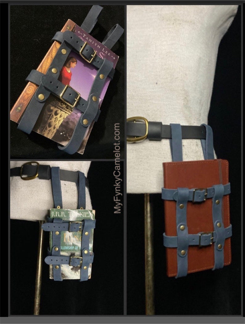 May include: A blue leather book holder with brass buckles and rivets, designed to be worn on a belt. The holder is shown with a book inside. The belt is black with a gold buckle. The website MyFynkyCamelot.com is visible.