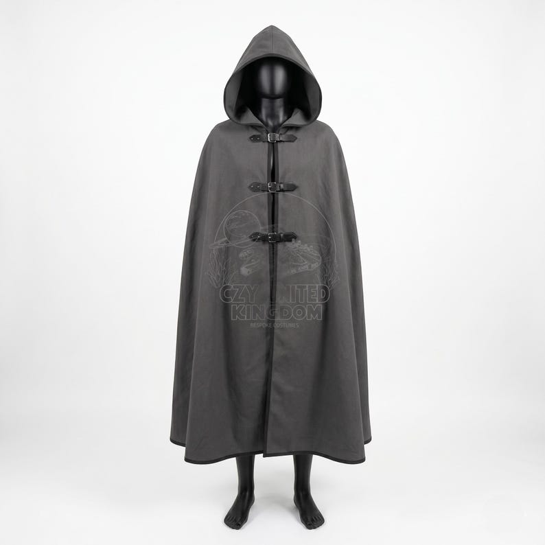 May include: A floor-length charcoal gray hooded cloak featuring three black leather-style straps with metal buckles down the front. The garment has a wide hood and a dark trim along the edges. A faint logo with the text CZY UNITED KINGDOM is visible.