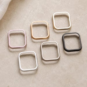 Pode incluir: Uma coleção de seis caixas de relógio retangulares em vários acabamentos metálicos, incluindo ouro rosa, ouro, prata, cinza fosco e preto. Cada moldura apresenta cantos arredondados e um centro oco, projetado para envolver um mostrador quadrado.