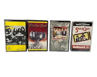May include: Four vintage Status Quo cassette tapes. The tapes feature album art with band photos and text. The cassette cases are black and clear, with yellow, red, and grey labels. The tapes are in good condition, showcasing classic rock music.