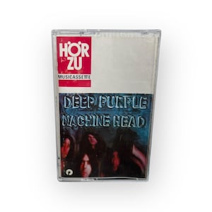 May include: A vintage cassette tape of the Deep Purple album "Machine Head." The cassette case is clear plastic. The label features the band's name and album title in a blue and white design, with the "Hör Zu" logo.