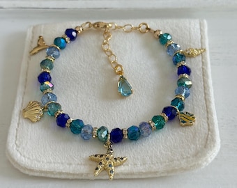Ocean theme multi charm with sparkly mix blue glass crystal beads 14K gold filled bracelet; dolphin tail, shells, starfish, marine charms