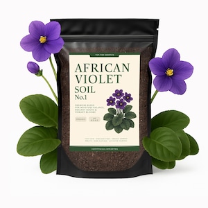 May include: A black bag of African Violet Soil No. 1, with a label featuring text and a purple violet illustration. Two purple African violet flowers and green leaves are arranged around the bag.