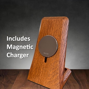 May include: A wooden phone stand with a built-in magnetic charger. The stand is made of dark wood with a natural grain pattern. The charger is a round, silver disc with a black label that says "Magnetic Charge".