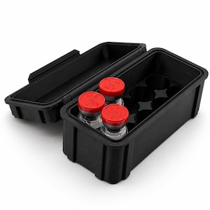 May include: A black rectangular storage case with a hinged lid, containing a moulded insert with circular slots. Three clear glass vials with bright red plastic flip-off caps are positioned within the slots, while the remaining slots are empty.