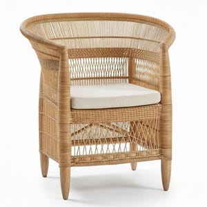 May include: A natural wicker armchair with a curved back and armrests. The chair features a woven design and a cream-colored cushion. The legs are made of wood. This chair is suitable for indoor or outdoor use.