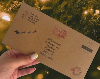 May include: A rectangular brown kraft paper envelope featuring black printed text addressed to Holly Snowbell at 25 Reindeer Lane, Tinseltown, North Pole, NP1 2HO, United Kingdom. It includes a Santa Claus graphic, a sleigh silhouette, and red stamps.