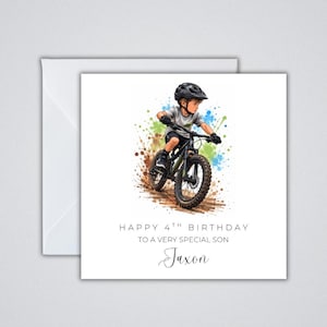 May include: A square greeting card featuring a watercolour-style illustration of a child wearing a black helmet and riding a mountain bike. Splashes of blue and green paint surround the cyclist. Text reads: HAPPY 4TH BIRTHDAY TO A VERY SPECIAL SON Jaxon.