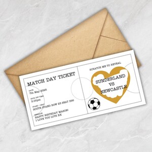 May include: A white match day ticket with the text "Match Day Ticket" and "Sunderland vs Newcastle" in a gold heart shape. The ticket includes the date, time, and seat information, with a soccer ball graphic. The ticket is inside a brown envelope.