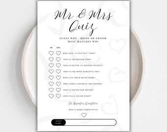 May include: A white Mr. & Mrs. Quiz game card with black text and heart graphics. The card includes questions like "Who said 'I love you' first?" and "Who is the better cook?" for a wedding or bridal shower activity.