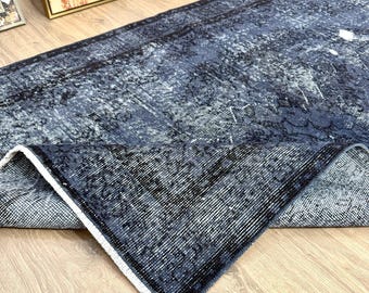 May include: A blue and white distressed rug with a faded pattern. The rug is folded in half and the edges are frayed.