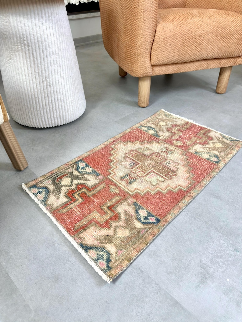 May include: A white ceramic mug with a black handle and the text "But First, Coffee" in a bold, black font. The mug is set against a blurred background, suggesting a cozy setting.