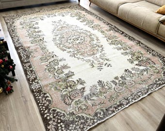 May include: A vintage-style rug with a floral pattern in shades of brown, pink, and white. The rug has a distressed look and is perfect for adding a touch of vintage charm to any room.