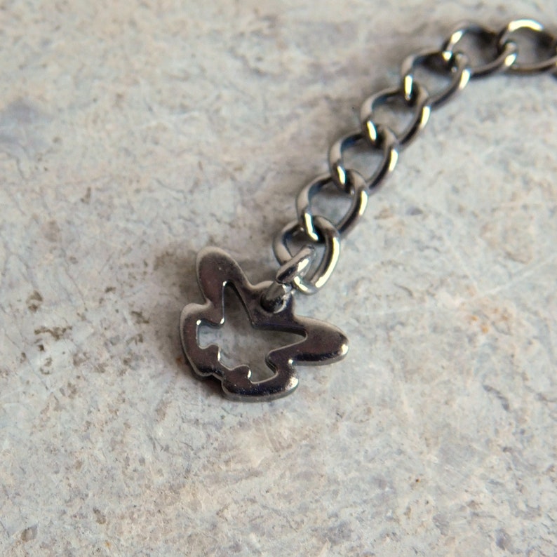 May include: A silver chain with a small, open-work bird charm attached.