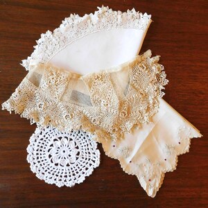 May include: Three white lace doilies, one with a scalloped edge, one with a delicate floral pattern, and one with a simple circular design.