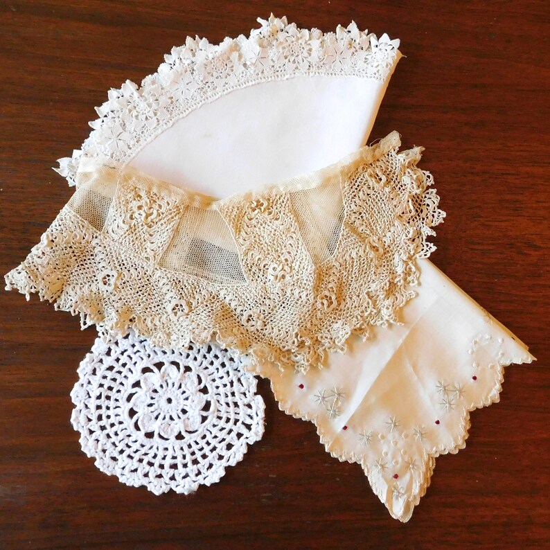 May include: Three white lace doilies, one with a scalloped edge, one with a delicate floral pattern, and one with a simple circular design.
