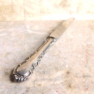 Un cuchillo antiguo Whiting Louis XV de 1891, de plata esterlina, con mango hueco y sin filo, de 23,5 cm (9 1/4"), sin monograma.