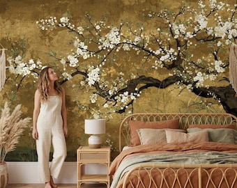 Könnte beinhalten: Ein Wandbild mit einem dunklen, strukturierten goldenen Hintergrund und einem großen, ausladenden Ast voller weißer Blüten. Das Wandbild erstreckt sich über die Wand hinter einem Bettgestell aus Rattan, einem Nachttisch aus Holz und Wandbehängen.