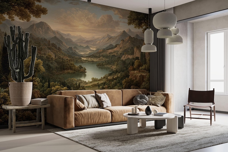 May include: A modern living room featuring a large landscape mural, a brown sectional sofa with decorative pillows, and a round coffee table. A large cactus in a pot sits on a wooden side table. The room is illuminated by pendant lights.