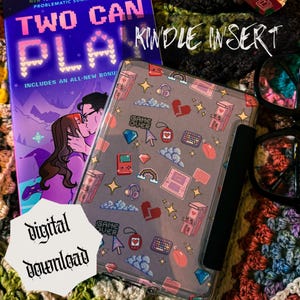 May include: A Kindle insert with a gray cover featuring a pattern of pixelated hearts, game controllers, and other gaming-related icons. The image also shows a book titled "Two Can Play" and the words "Digital Download".
