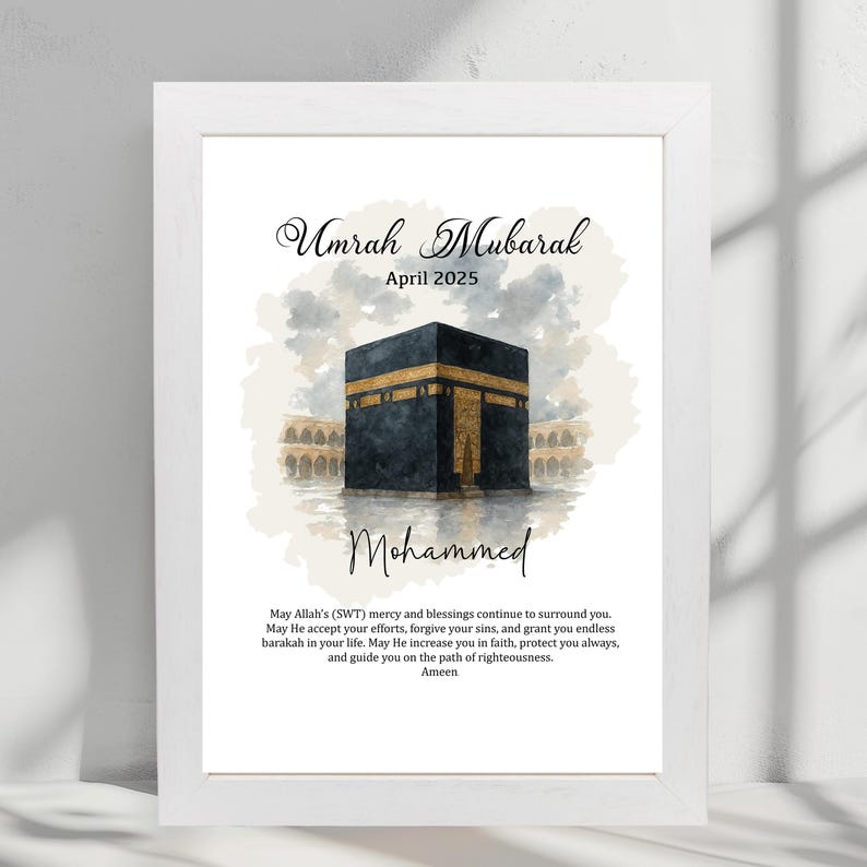 May include: A watercolor illustration of the Kaaba in Mecca, Saudi Arabia. The image is in shades of gray and gold with a white background. The text "Umrah Mubarak" and "April 2025" is at the top of the image. The text "Mohammed" is below the image of the Kaaba. The text "May Allah's (SWT) mercy and blessings continue to surround you. May He accept your efforts, forgive your sins, and grant you endless barakah in your life. May He increase you in faith, protect you always, and guide you on the path of righteousness. Ameen" is at the bottom of the image.
