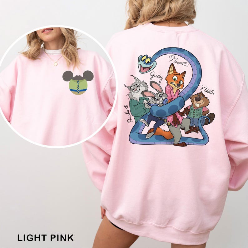 May include: Light pink sweatshirt featuring a cartoon graphic on the back with a blue snake and several animal characters. The front has a small Mickey Mouse-inspired design. The text "LIGHT PINK" is at the bottom.