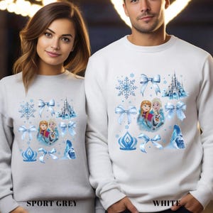 May include: Sport grey and white sweatshirts featuring a winter-themed design. The design includes images of snowflakes, bows, a castle, and characters from a popular animated film. The text "SPORT GREY" and "WHITE" are printed at the bottom.