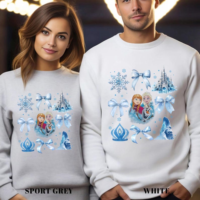 May include: Sport grey and white sweatshirts featuring a winter-themed design. The design includes images of snowflakes, bows, a castle, and characters from a popular animated film. The text "SPORT GREY" and "WHITE" are printed at the bottom.