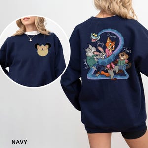 May include: Navy blue sweatshirt featuring a cartoon design of characters from a movie. The design includes a snake, a fox, a rabbit, a cat, and a beaver. The sweatshirt also has a small cartoon character on the front. The word "NAVY" is at the bottom.