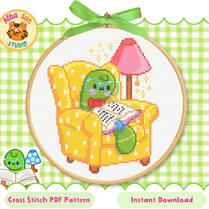 May include: A cross-stitch pattern featuring a cartoon turtle wearing glasses and a bow tie, reading in a yellow armchair with a pink lamp. The design is set in a wooden hoop with the text "Cross Stitch PDF Pattern" and "Instant Download".