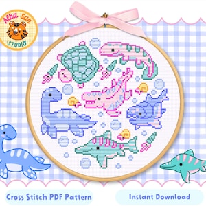 Puede incluir: Un patrón de punto de cruz con criaturas marinas en tonos azules, rosas y verdes, incluyendo una tortuga, un dinosaurio y un pez, dentro de un bastidor de bordado de madera. El texto dice "Cross Stitch PDF Pattern" y "Instant Download".